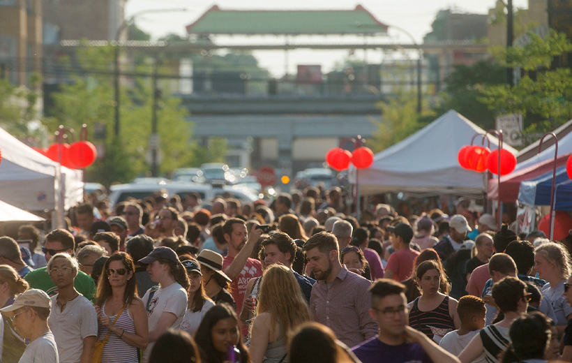 Street fest full of people on Argyle Street in Chicago, beneath Argyle Red Line 'L' station
