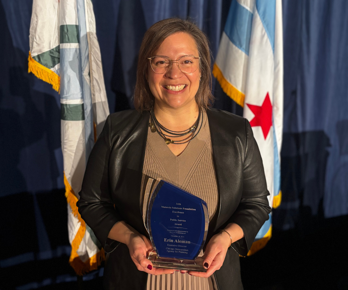 Someone holds an award that is glass with a blue background