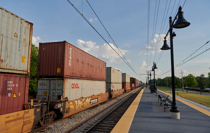 Freight trains passing through a commuter station