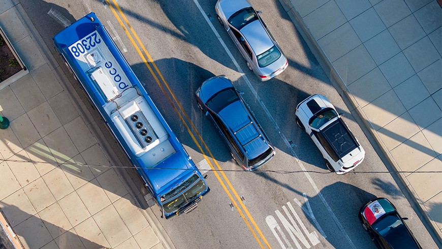 Birds eye view of a Pace bus passing four cars in opposite direction