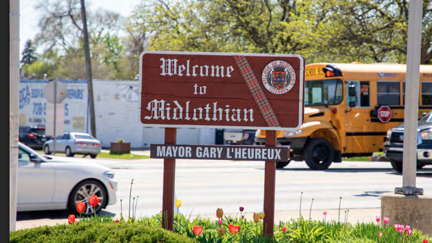 A 'Welcome to Midlothian' sign with the village seal and 'Mayor Gary L'Heureux' plaque