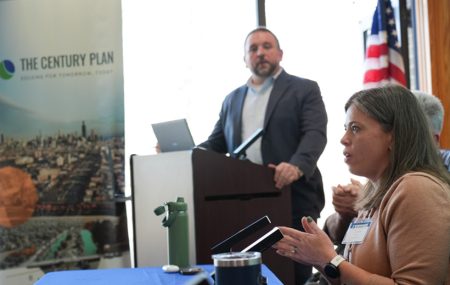 Photo of panelist speaking and facilitator standing at a podium