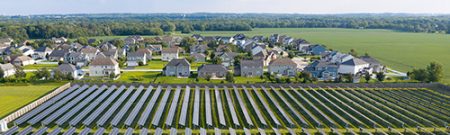aerial photograph of a solar farm near a housing development