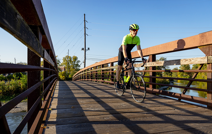 Person riding bike over pedestrian bridge