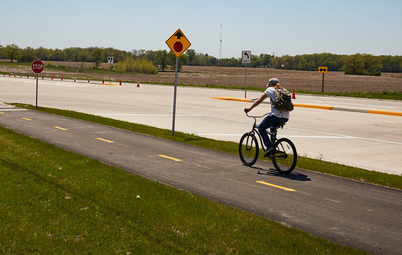 Cyclist riding down a bike lane beside a roadway.