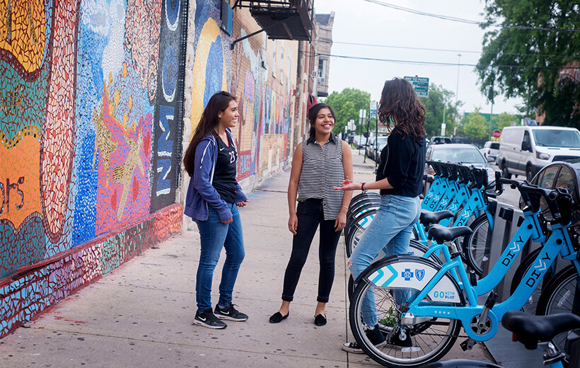 Three people standing next to Divvy bikes, enjoying a conversation