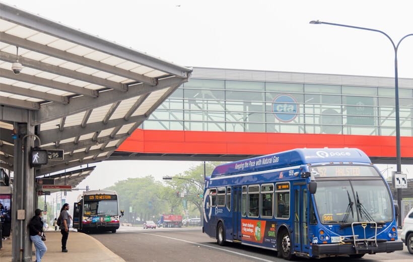 Buses navigating a foggy bus and train station.