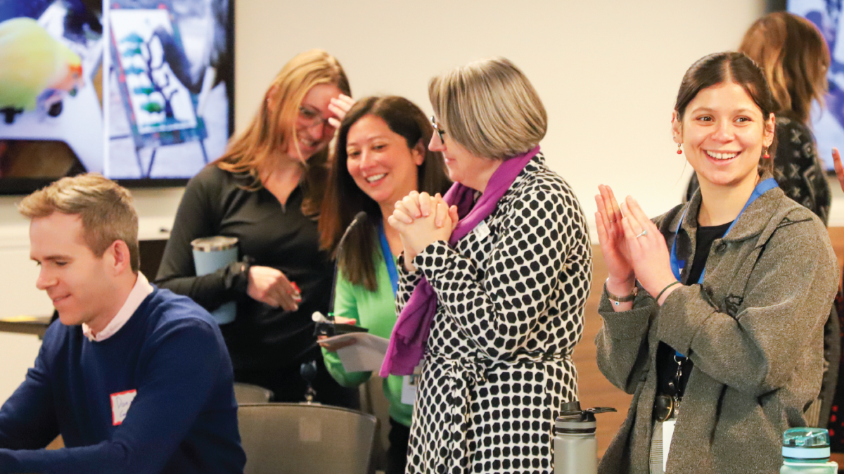 Five people smile and clap in CMAP's office